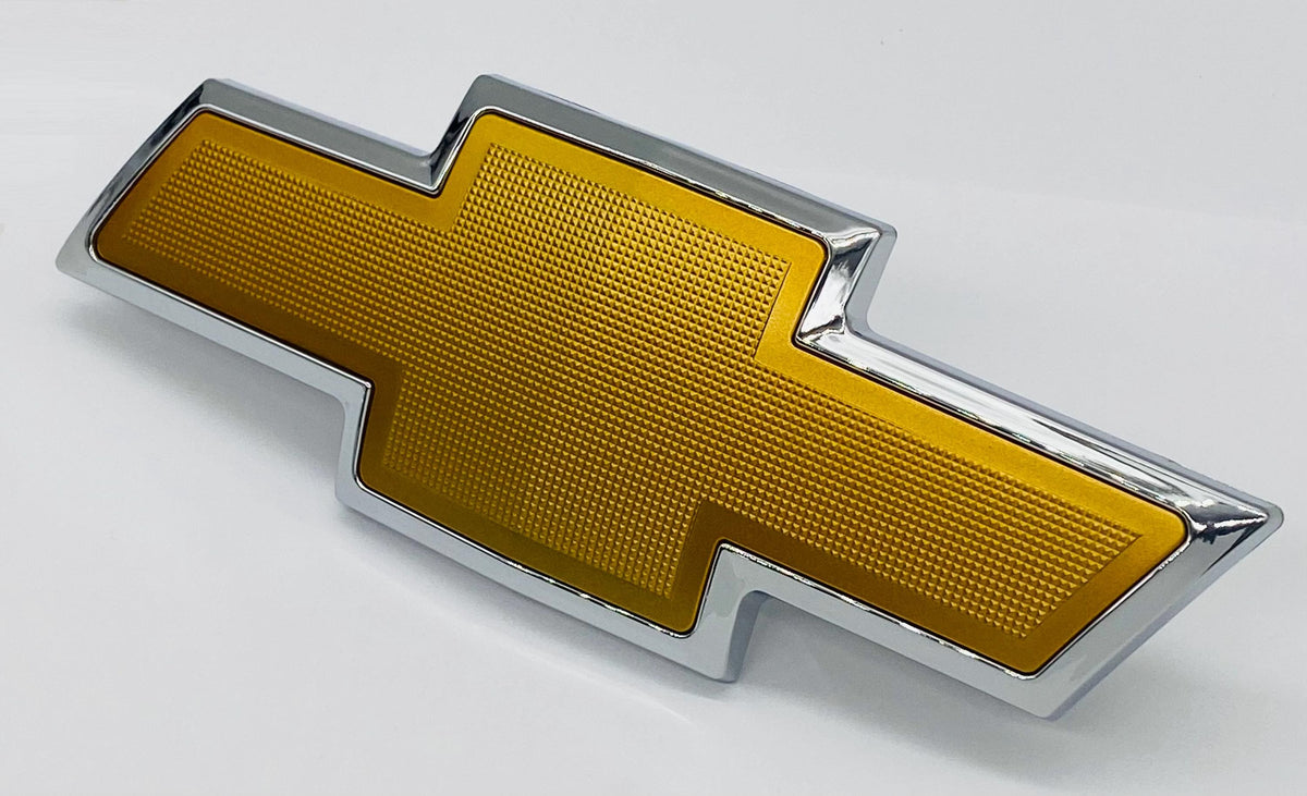 Rear tailgate bowtie emblem, chrome with gold center, angled view